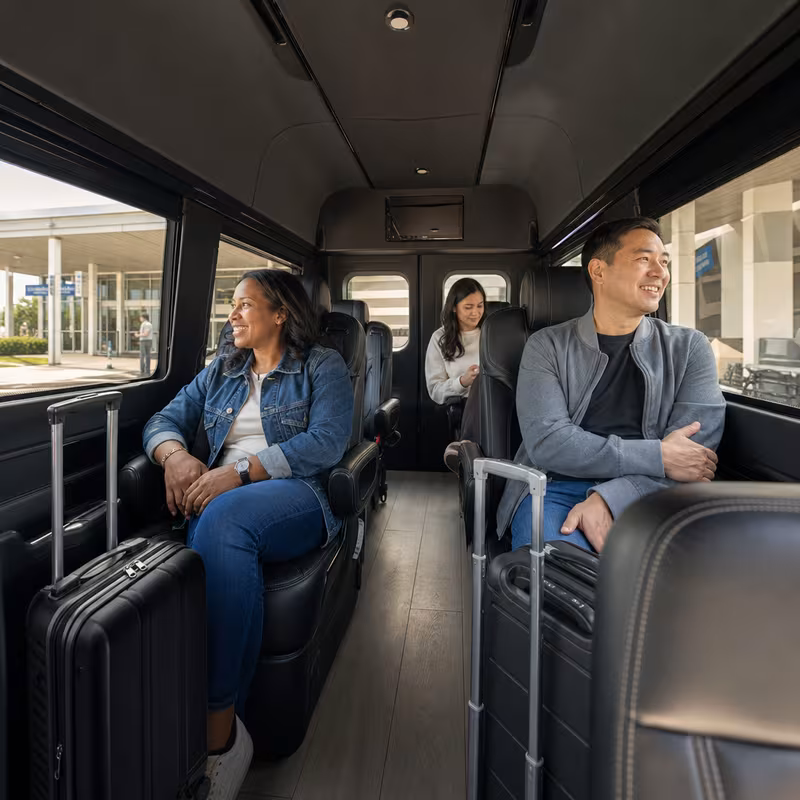 Passengers loading luggage while boarding an Augusta group shuttle