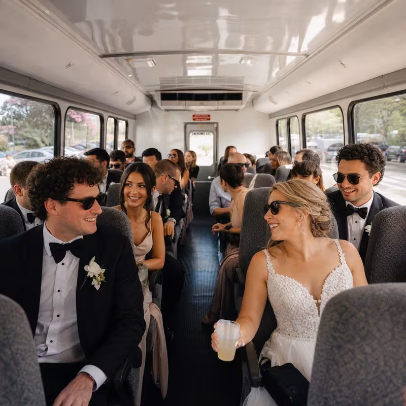 Group boarding a white charter bus for Wedding Transportation transportation in Augusta